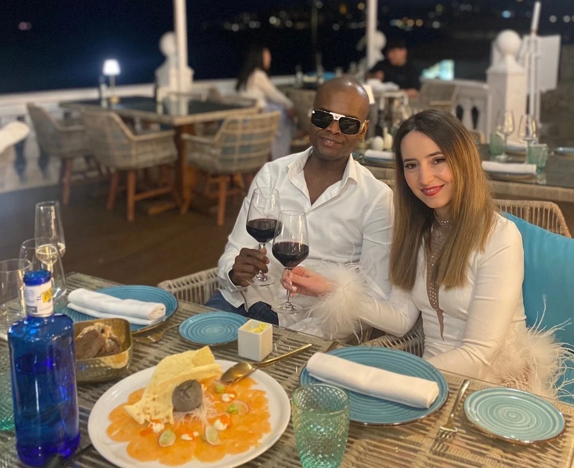 Ein Paar stößt bei einem Abendessen am Meer mit Wein an
