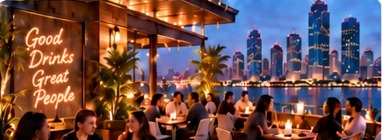 Rooftop bar with a neon sign reading Good Drinks Great People